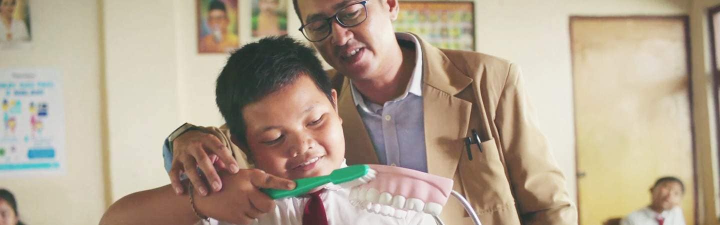 Tenaga Pengajar sedang memberikan edukasi sikat gigi yang baik dna benar