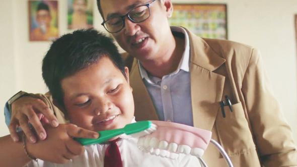Tenaga Pengajar sedang memberikan edukasi sikat gigi yang baik dna benar